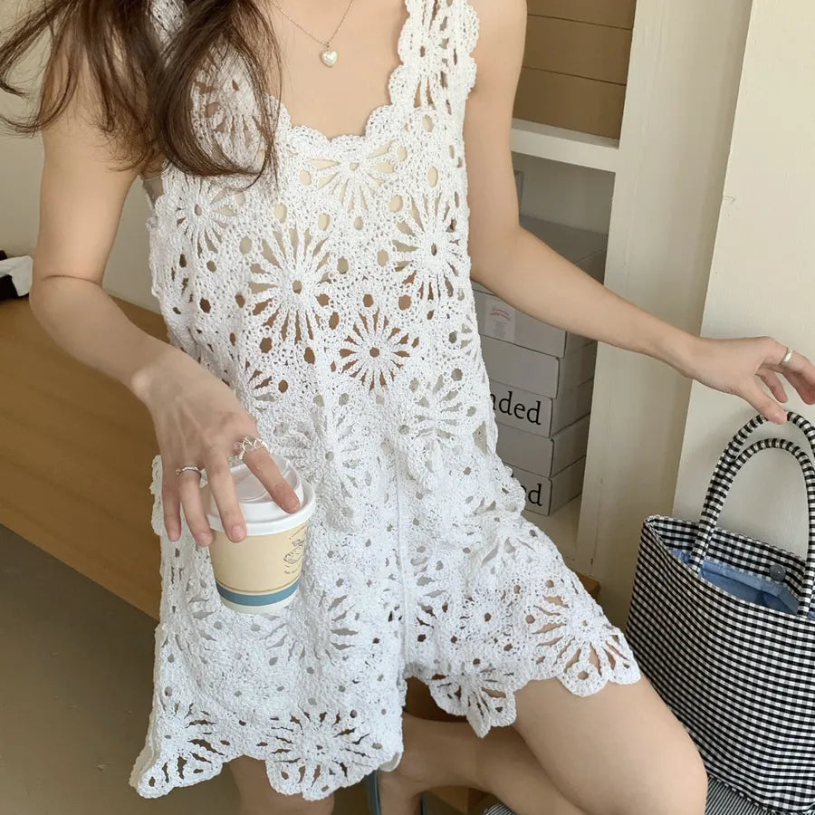 Woman wearing a white lace dress holding a coffee cup indoors.