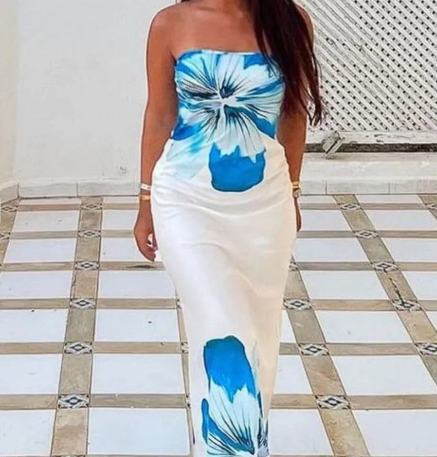 Woman wearing a strapless dress with blue and white tie-dye pattern on a tiled floor. Vacation resort dress