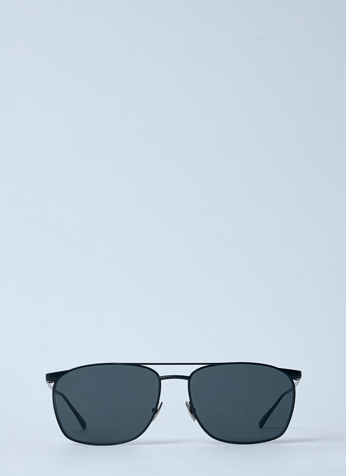 Sunglasses with dark lenses on a light blue background