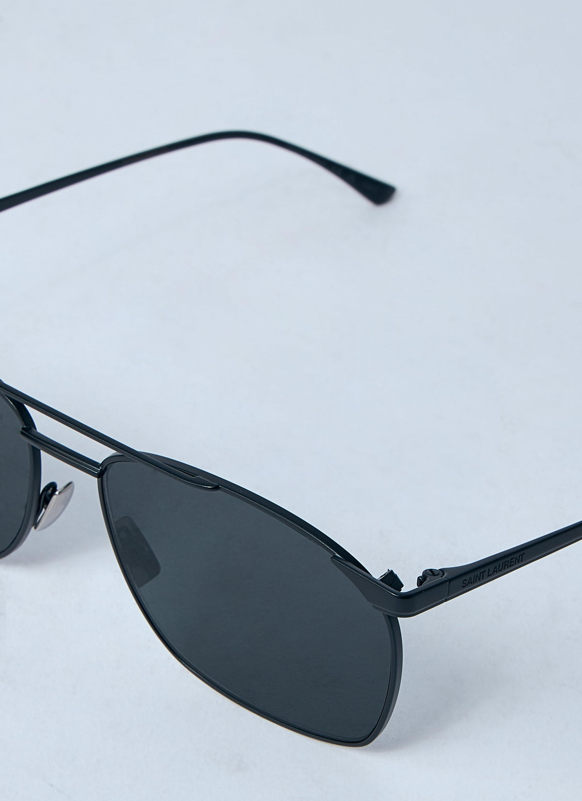 Black sunglasses with dark lenses on a light gray background